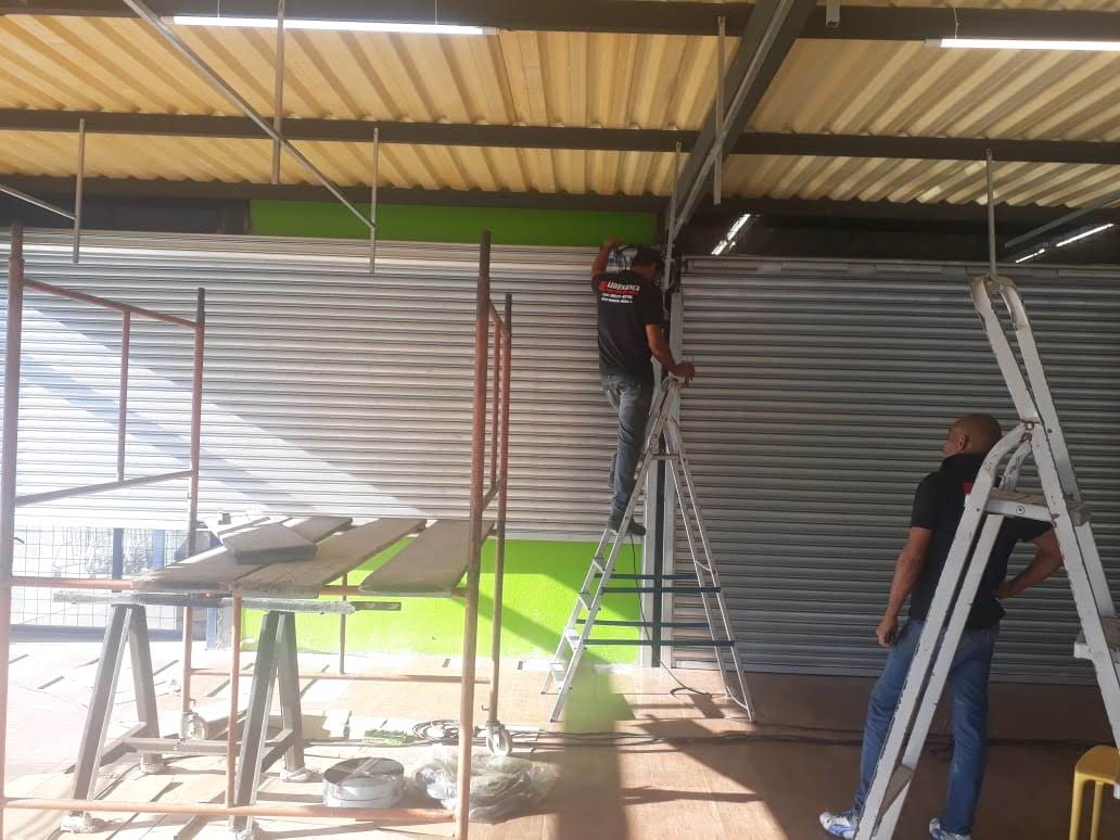Equipe da Liderança Portas de Aço fazendo manutenção de porta de aço